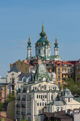 Fototapeta premium A captivating image of an Eastern Orthodox church, showcasing multiple onion-domes, standing as a central landmark in a densely built-up urban area The structure is richly a - Kyiv, Ukraine 06-11-2024
