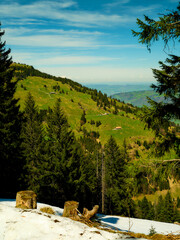 Stunning view of green hills and snow in a mountain landscape during a sunny day