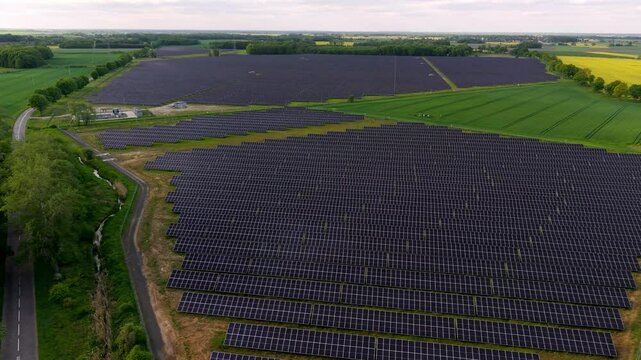 Drone footage of a solar farm showcasing photovoltaic panels converting sunlight into energy. Aerial views highlight sustainability, clean energy, and harmony between technology and nature.