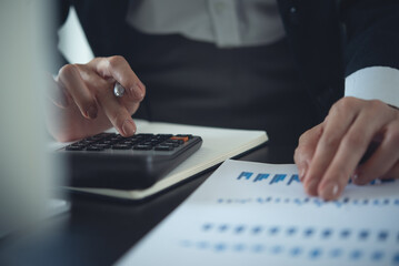 Business financing accounting banking concept. Business woman hand doing finances and calculate with financial report on office table. Woman working on desk with using calculator, finance accounting