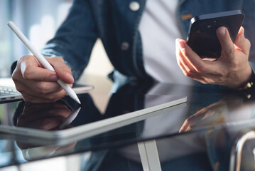 Closeup, business woman  using digital tablet and mobile phone, online working at home office. Student studying online, surfing the internet, searching the information, e-learning, business technology