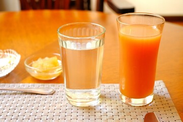 glass of water and glass of vegetable mix juice on the table in morning