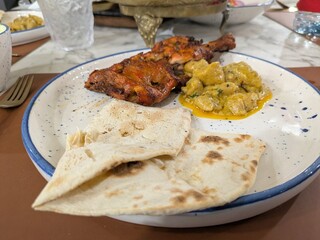 indian food, tandoori chicken, basmati rice, naan bread, colorful plates, restaurant setting, high quality, realistic, detailed, 4k
