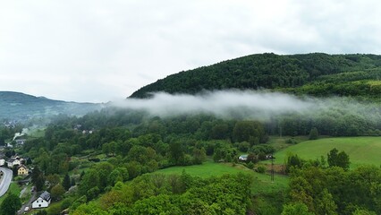 A majestic mountain partially shrouded in fog, creating a mystical and dramatic atmosphere. A...