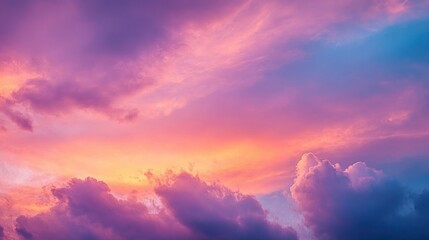 Naklejka premium Vibrant sunset sky with colorful cloud formations in shades of pink, purple, orange, and blue creating a serene and peaceful atmosphere