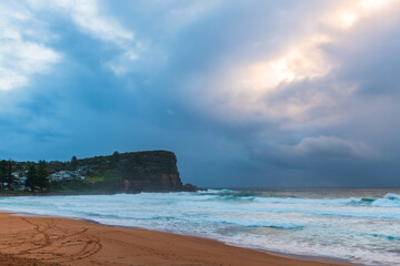 Moody sunrise with waves at the seaside