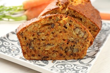 Cut homemade carrot cake with nuts on table, closeup