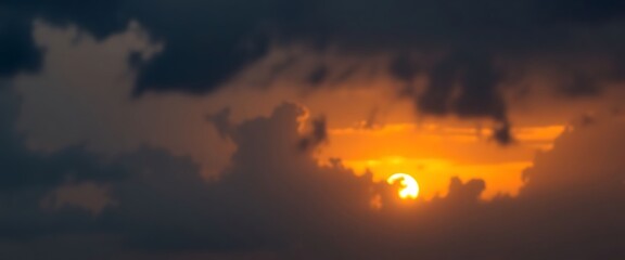 sun is setting in the cloudy sky