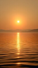 Obraz premium Scenic Golden Sunset Over Calm Water with Mountain Silhouettes and Sun Reflection