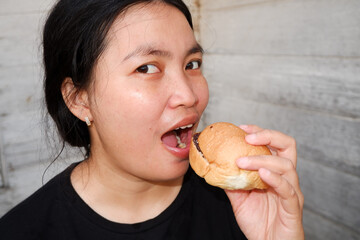 Facial expression of an Asian woman eating bread. Close-Up photo 