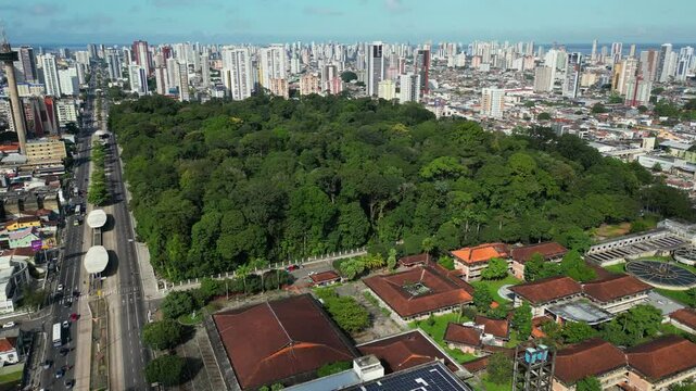Aerial drone footage of Belem, Para, BR, cityscape featuring preserved forest in the "Rodrigues Alves" park and botanical garden between dense urban development