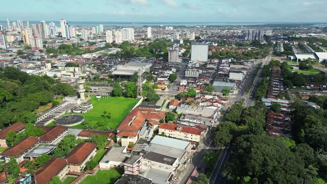 Aerial drone footage of Belem, Para, BR, cityscape featuring preserved forest in the "Rodrigues Alves" park and botanical garden between dense urban development