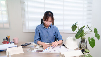 Asian Adult Woman Architect Working on Blueprint in Office Engineering and Architectural Design for Construction Industry and Residential Planning