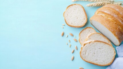 Slices of freshly baked bread are arranged beside whole grains on a light blue surface, showcasing a simple and cozy culinary setting