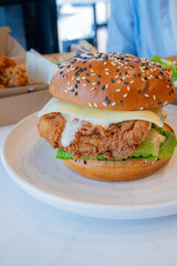 Deep-fried boneless Korean chicken burger with sweet buns. Crispy outside, juicy and succulent inside, smelling delicious.