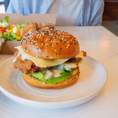 Deep-fried boneless Korean chicken burger with sweet buns. Crispy outside, juicy and succulent inside, smelling delicious.
