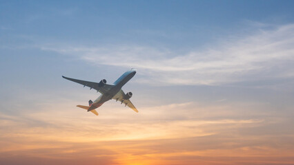 commercial airplane flying above over sky in sunset light.