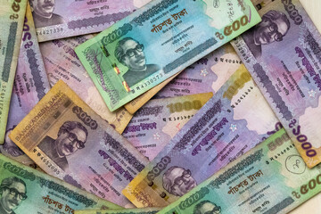 Five hundred and one thousand taka banknotes (BDT 1000 and BDT 500) as a background.