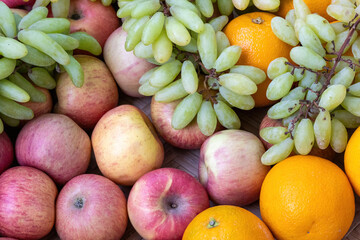 Mixed fruits background. Delicious apple, sweet orange (or Malta fruit), and green grapes, representing a healthy diet concept.