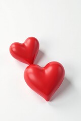 Two Red Hearts Resting Side by Side on a Plain White Background