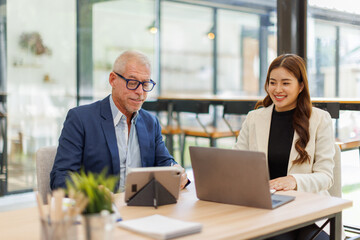 Obraz premium Financial Two business people analyze the graph of the company's performance to create profits and growth, Market research reports and income statistics, Financial and Accounting concept. 