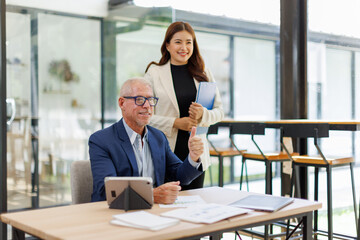 Team of confident business people point to graphs and charts to analyze market data, balance sheet, account, net profit to plan new sales strategies to increase production capacity.	