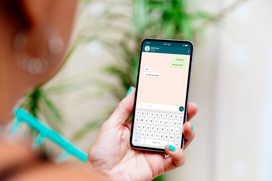 Woman holding a mobile phone showing a chat app on the screen. Communication technology, apps.