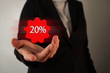 A woman is holding a 3d  red button that says 20% off. 