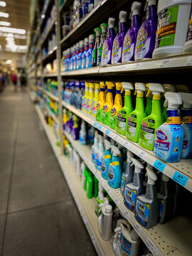 shelves stocked with various cleaning products, primarily bleach and mold or mildew removers, in a hardware store setting