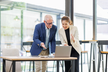Businessman and Woman Working Together on Laptop in Contemporary Office.Successful Team Meeting with Digital Device in Stylish Office Setting
