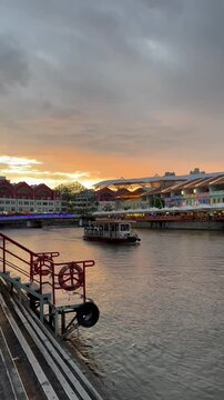 Sunset Scene at Clarke Quay with Boat Passing by in Singapore