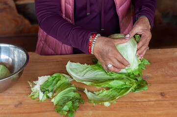 Cook removing outer leaves of lettuce on wooden table