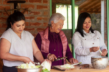 Latin american women preparing traditional food in rustic kitchen