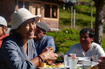 Latin american woman enjoying a meal with family outdoors