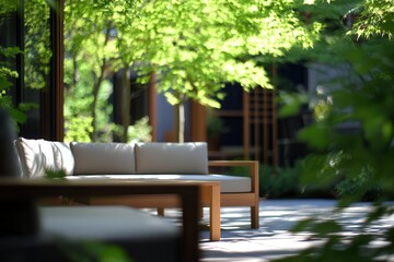 Obraz premium Serene outdoor lounge area with modern furniture surrounded by lush greenery and soft sunlight