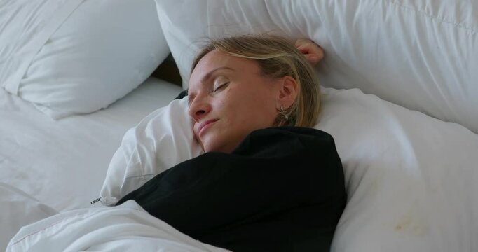 Pretty woman sleeping on bed in cozy bedroom environment. Take a nap at daytime. 