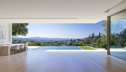 A modern interior with large glass doors opens to reveal a panoramic view of a valley, a swimming pool, and lush greenery