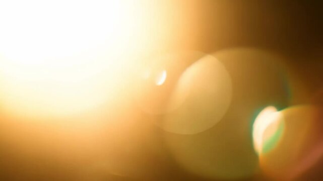 Dramatic lens flare progression over abstract golden light and bokeh effects