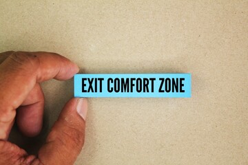Hands and colored paper with the words Exit comfort zone. Small steps, reframing stress, and embracing challenges like learning new skills