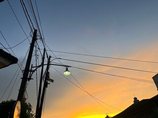 This photo beautifully captures the moment of sunset in an urban neighborhood. The sky is painted...