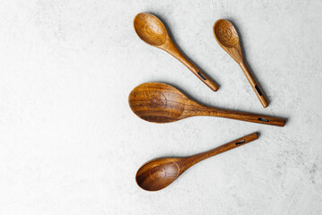 Wooden kitchen spoons arranged on a gray background for culinary use