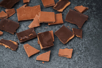 Chocolate pieces on a dark surface display diverse textures and colors