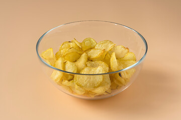 Potatoes Chips , high-resolution. Side view of an isolated glass bowl with a pile of potato chips...