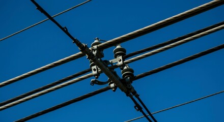 Close-up of overhead power lines crossing