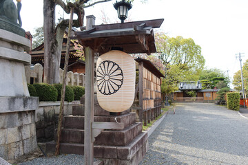 Kyoto, Japan - April 15, 2024: Fox statues, the messengers of the gods, and white paper lanterns...