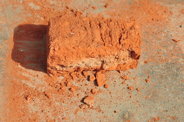 Single broken red brick on concrete
