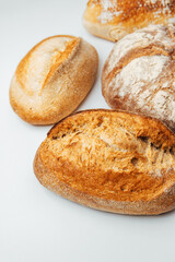 Freshly baked artisan bread varieties on a white surface