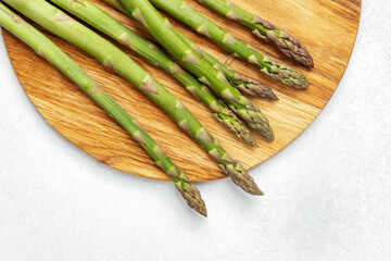 Fresh green asparagus on a wooden cutting board ready for cooking