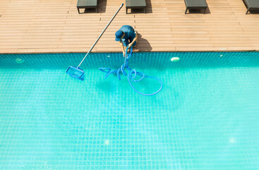 Pool maintenance with scoop net  and automatic robot cleaner.