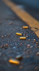 Spent bullet casings littering asphalt road surface with yellow line at dusk crime scene low angle view